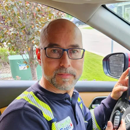 Carlos, technician at Car Keys Geeks, programming a Nissan key fob with a diagnostic tablet